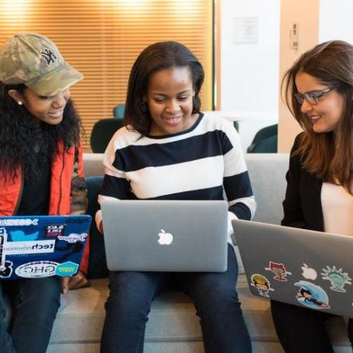 Three students looking at laptops